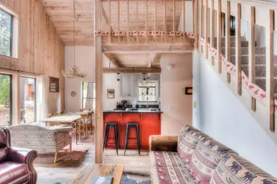 a tiny house with a staircase in the living room at Relax at Rustic Tahoe Charm - Minutes to Lake in Tahoma