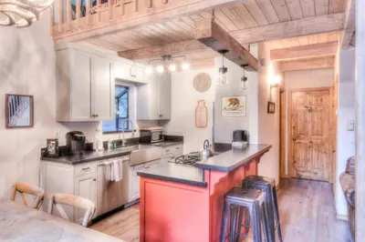 a kitchen with white cabinets and a red island at Relax at Rustic Tahoe Charm - Minutes to Lake in Tahoma