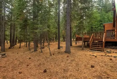 a cabin in the woods with a deck and stairs at Serenity at Tahoe Donner with Large Balcony in Truckee