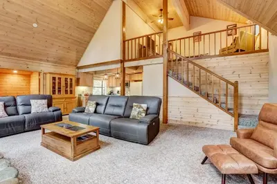 a living room with two couches and a staircase at Serenity at Tahoe Donner with Large Balcony in Truckee