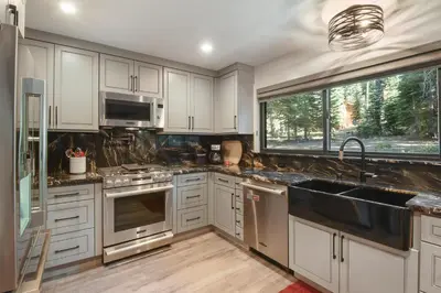 a kitchen with white cabinets and stainless steel appliances at Serenity on Statford - Close to Northstar in Tahoe Vista