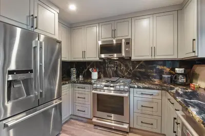 a kitchen with white cabinets and stainless steel appliances at Serenity on Statford - Close to Northstar in Tahoe Vista