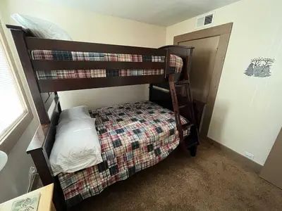 a bedroom with a bunk bed and a bed with a pillow at Silver Tree Sanctuary in Aspen Grove in Truckee