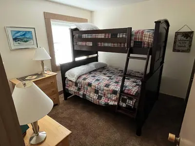 a bedroom with two bunk beds and a desk with a lamp at Silver Tree Sanctuary in Aspen Grove in Truckee