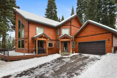 a wooden house with a garage in the snow at Skislope Sanctuary - Close to Outdoor Activities in Truckee