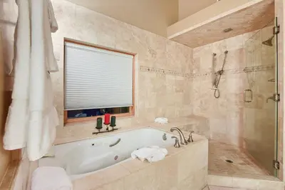 a bathroom with a tub and a shower with a window at Skislope Sanctuary - Close to Outdoor Activities in Truckee