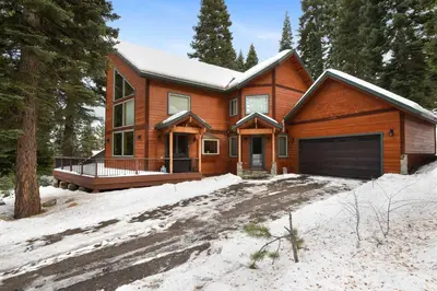 a wooden house with a garage in the snow at Skislope Sanctuary - Close to Outdoor Activities in Truckee