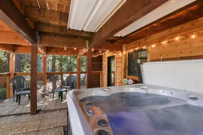 a jacuzzi tub on a porch of a cabin at Snowshoe Cabin - 3 Decks BBQ & Hot Tub in Tahoe City
