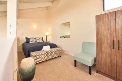 a small bedroom with a bed and a chair at Tahoe Lakeside Retreat - Lakefront Condo in South Lake Tahoe