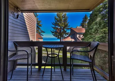 a balcony with a table and chairs on a porch at Tahoe Lakeside Retreat - Lakefront Condo in South Lake Tahoe