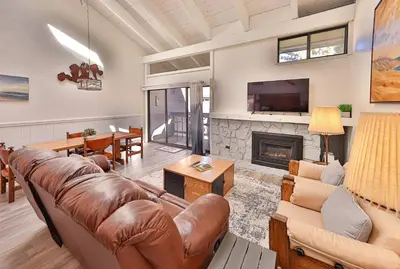 a living room with a couch and a fireplace at Tahoe Lakeside Retreat - Lakefront Condo in South Lake Tahoe