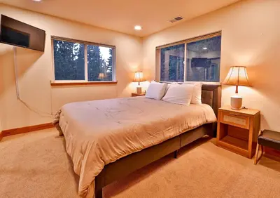 a bedroom with a large bed with two windows at The Elevator House - Sleeps 10 in Stateline