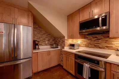 a kitchen with wooden cabinets and stainless steel appliances at The Meadows - Ski Lease - Extended 30 Plus Days in South Lake Tahoe