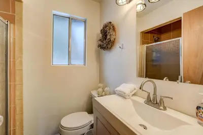 a bathroom with a sink and a toilet and a window at Whispering Pines Cabin - Family & Pet Friendly Abode in South Lake Tahoe