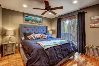 a bedroom with a blue bed and a ceiling fan at Willow's Hideaway - Pet Friendly Cozy Cabin in South Lake Tahoe