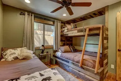 two bunk beds in a room with a ceiling fan at Willow's Hideaway - Pet Friendly Cozy Cabin in South Lake Tahoe