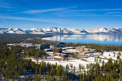 an aerial view of a resort on a lake with snow covered mountains at Willow's Hideaway - Pet Friendly Cozy Cabin in South Lake Tahoe