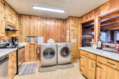 a washer and dryer in a kitchen with wooden cabinets at Zephyr Cove Cabin - Walk to Lake & Beach in Zephyr Cove