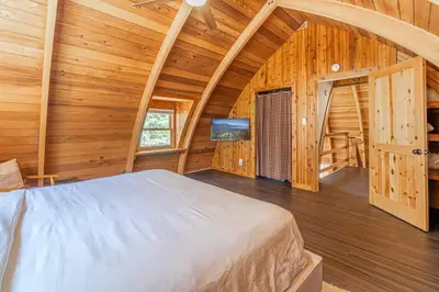 a bedroom with a large bed in a wooden cabin at Canoe Cabin I Sleeps 8 I Hot Tub I Pet Friendly in Incline Village