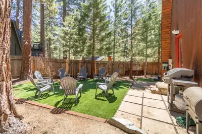 a backyard with lawn chairs and a grill at Canoe Cabin I Sleeps 8 I Hot Tub I Pet Friendly in Incline Village