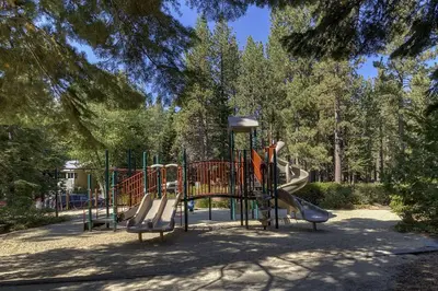 a playground with a slide in a park at Misty Pines by Tahoe Getaways at Tahoe Park - Newly Remodeled Pet Friendly 3 BR w Private Beach HOA in Tahoe City
