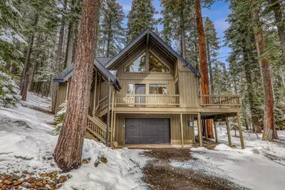 a house in the woods in the snow at Misty Pines by Tahoe Getaways at Tahoe Park - Newly Remodeled Pet Friendly 3 BR w Private Beach HOA in Tahoe City