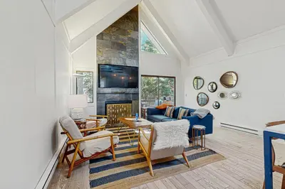 a living room with a blue couch and a fireplace at Family Friendly! Incline Village Condo with Foosball in Tyrolian Village