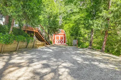 a driveway with a house with a gate and trees at Peaceful Forest Views and Patio Twain Harte Home in Twain Harte