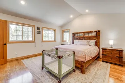 a bedroom with a bed and a dresser and windows at 5 Mi to Northstar Resort! Family Home with Hot Tub in Truckee