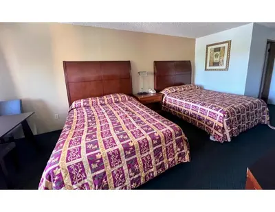 a hotel room with two beds and a table at Oasis Inn and Suites in Fallon