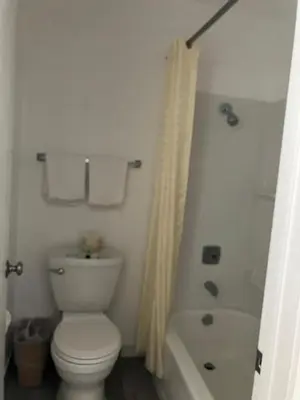 a bathroom with a toilet and a tub and a shower at Oasis Inn and Suites in Fallon