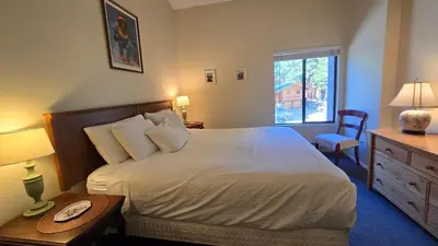 a bedroom with a bed and a table and a window at Eagle Summit Collection in Mammoth Lakes