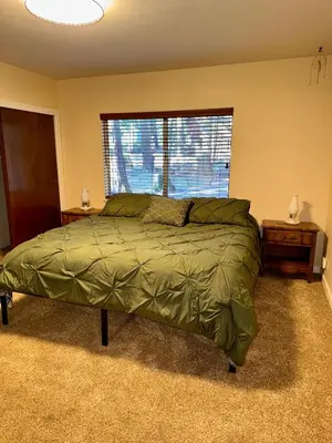 a bedroom with a large bed and a window at Bear Meadow Cabin at Shaver Lake in Shaver Lake