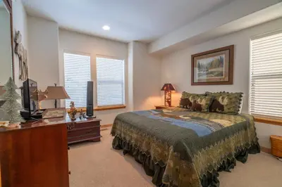 a bedroom with a bed and a desk and windows at RR-Hideaway_Down_Cyn 104 in June Lake