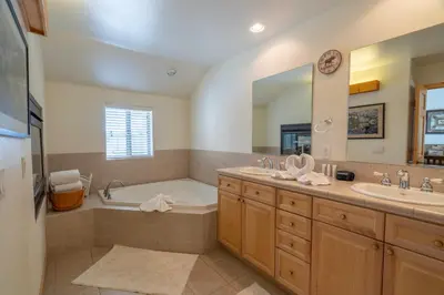 a bathroom with two sinks and a bath tub and a mirror at RR-Hideaway_Down_Cyn 104 in June Lake