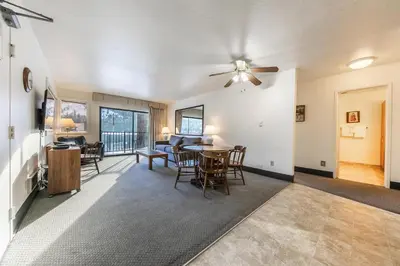 a living room with a ceiling fan and a table and chairs at 136 Bldg C condo in Truckee