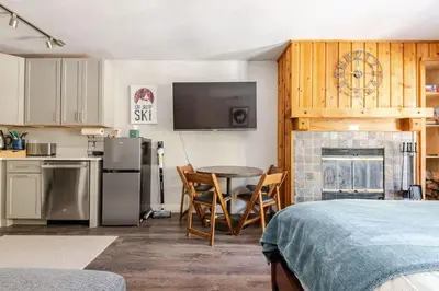 a room with a kitchen with a table and a fireplace at Kirkwood Studio Full Kitchen & Meadow Balcony in Kirkwood