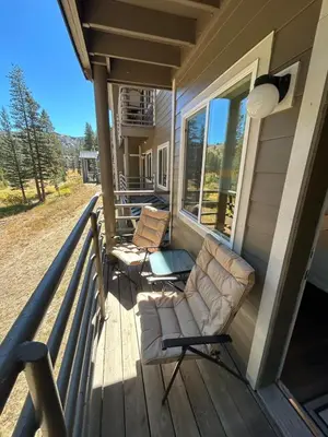 a porch with two chairs and a table on a house at Kirkwood Studio Full Kitchen & Meadow Balcony in Kirkwood