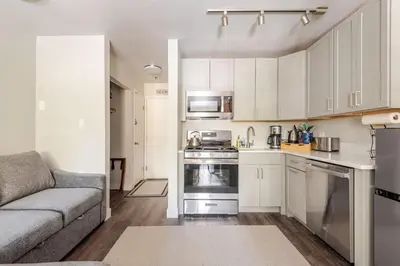 a kitchen with white cabinets and a couch in a room at Kirkwood Studio Full Kitchen & Meadow Balcony in Kirkwood