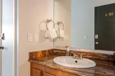 a bathroom with a sink and a large mirror at The Lookout Loft Great views and King Sized Bed in Kirkwood