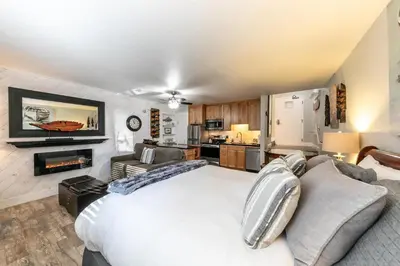 a bedroom with a white bed and a kitchen at 125 Bldg B condo in Truckee