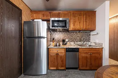 a kitchen with wooden cabinets and a stainless steel refrigerator at 113 Bldg B studio in Truckee