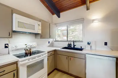a kitchen with white appliances and a window at Mammoth Point 119 in Mammoth Lakes