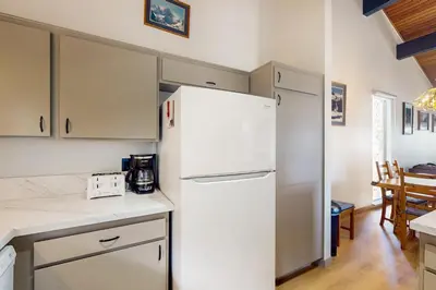 a kitchen with a white refrigerator and a table at Mammoth Point 119 in Mammoth Lakes