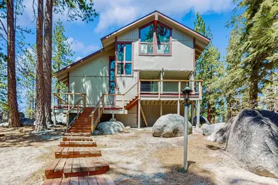 a house in the woods with stairs leading up to it at The Bunk and Birch Retreat in South Lake Tahoe