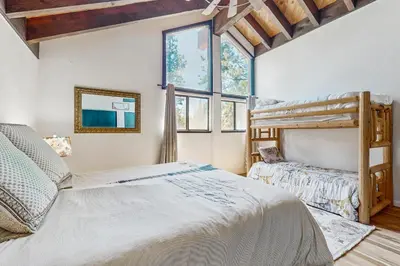a bedroom with two bunk beds and a window at The Bunk and Birch Retreat in South Lake Tahoe