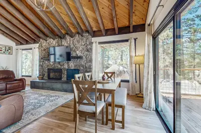 a living room with a table and chairs and a tv at The Bunk and Birch Retreat in South Lake Tahoe