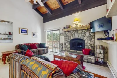a living room with couches and a stone fireplace at Woodstock and Snoopy in Incline Village