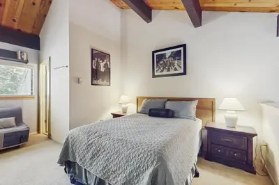 a bedroom with a bed and two lamps and a chair at Woodstock and Snoopy in Incline Village