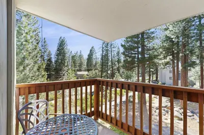 a balcony with a table and chairs and trees at Woodstock and Snoopy in Incline Village